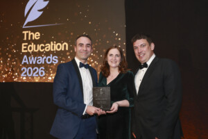 Two men in black tie and one woman, accepting an award at the Education Awards 2026.